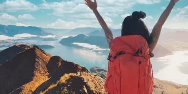 Asian woman hiker climbing up on the peak of mountain