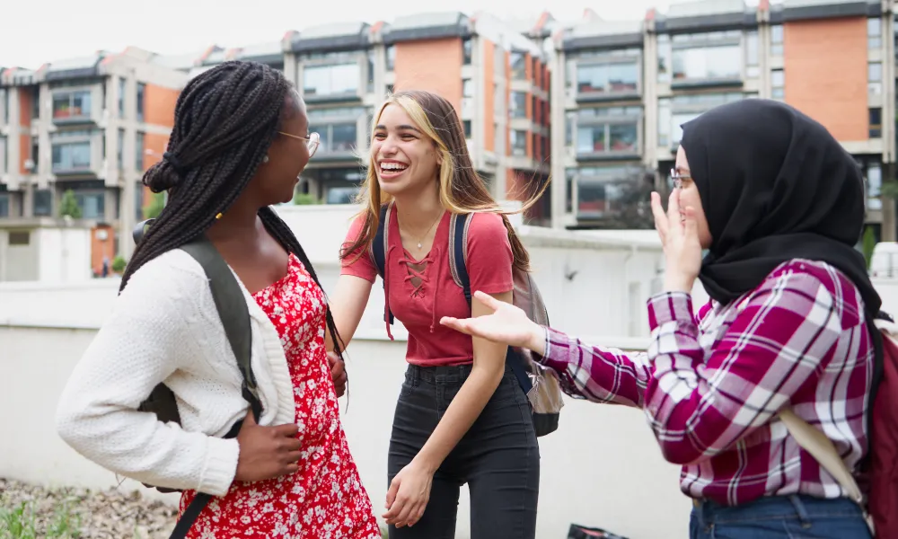 Friends talking and laughing in campus