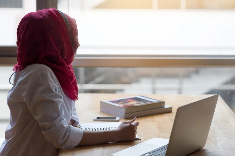 Student wearing head scarf looking left