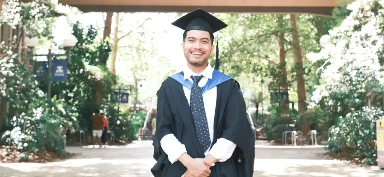 IDP IELTS test taker Adi graduating in park setting