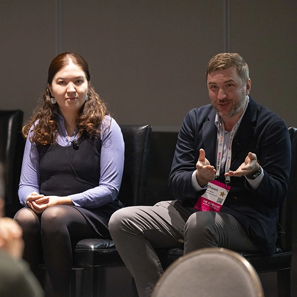 Gulnaz Kordanova and Shawn Wolfe speaking during a panel at PIE Live North America