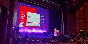 Speaker presenting on stage during an IELTS opening plenary session