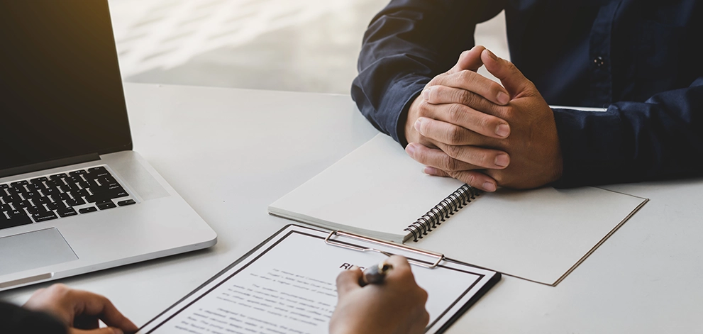Candidate attending a job interview with an interviewer at a desk
