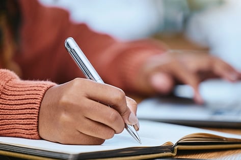 Student writing notes close-up