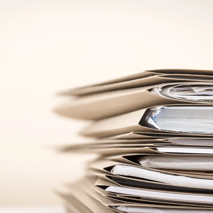Stack of paper files and documents organised in folders
