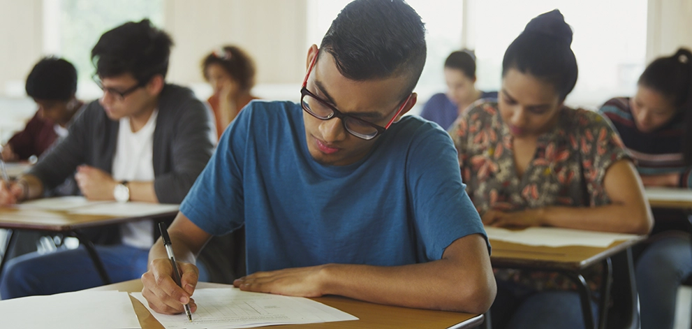 Student writing exam classroom