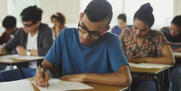Student writing exam classroom