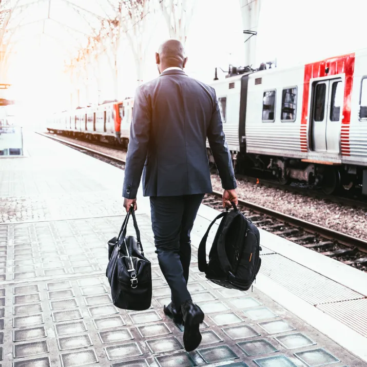 Professional traveller walking beside a train platform representing global opportunities with IELTS