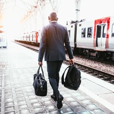 Professional traveller walking beside a train platform representing global opportunities with IELTS