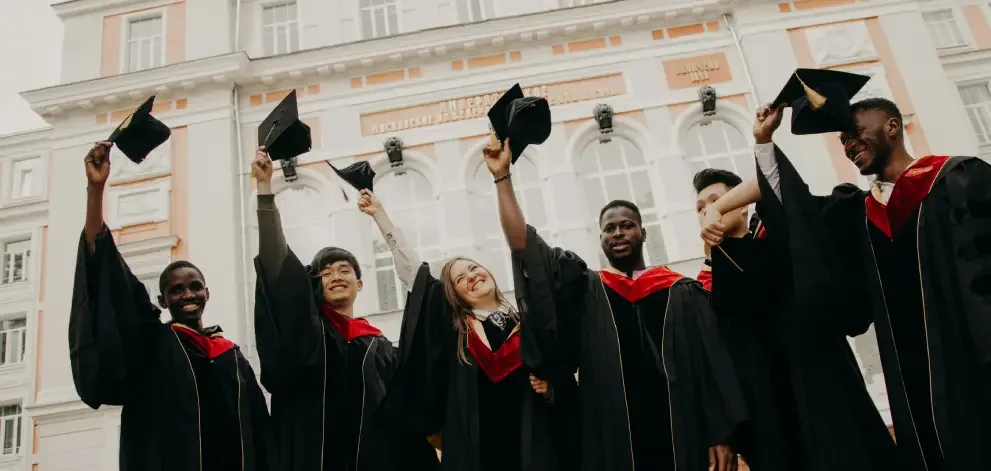 Group of graduates celebrating in front of a building