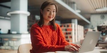 Student using a laptop while studying in a library