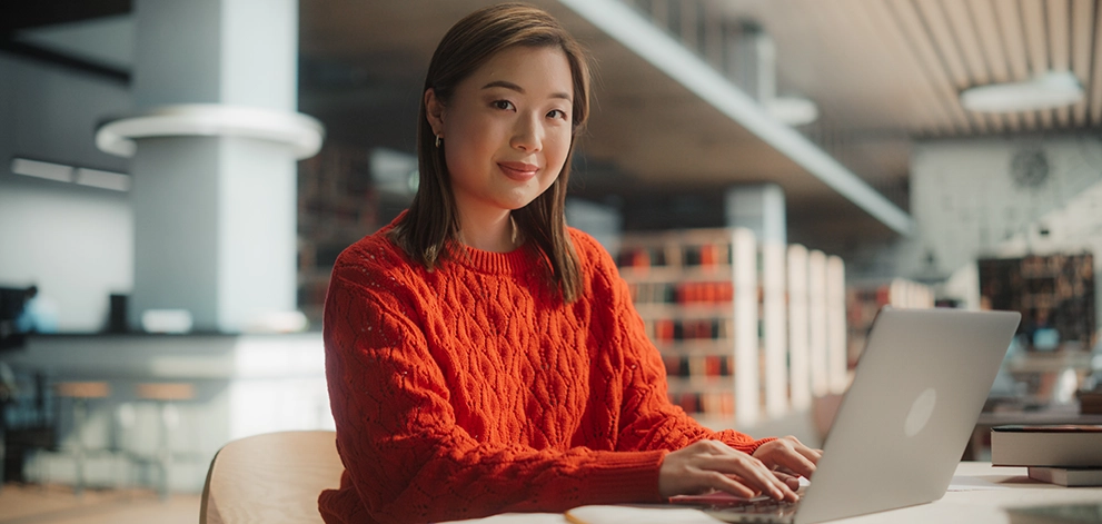 Student using a laptop while studying in a library