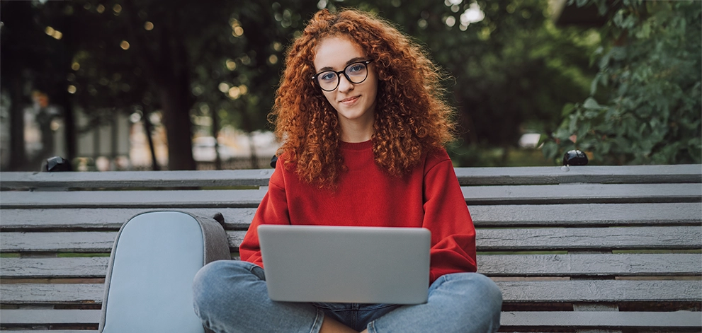 Student studying laptop outdoors university preparation
