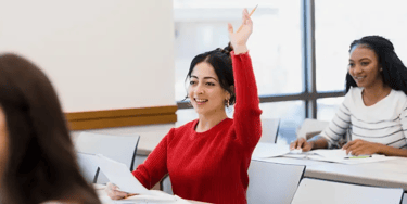 Student raising hand in classroom
