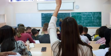 Student raising hand in lecture hall