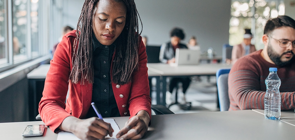 Student writing during a test in a classroom