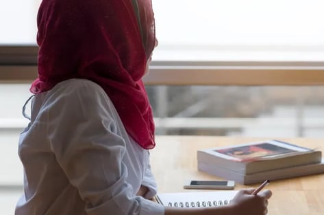 Student head scarf looking out of the window