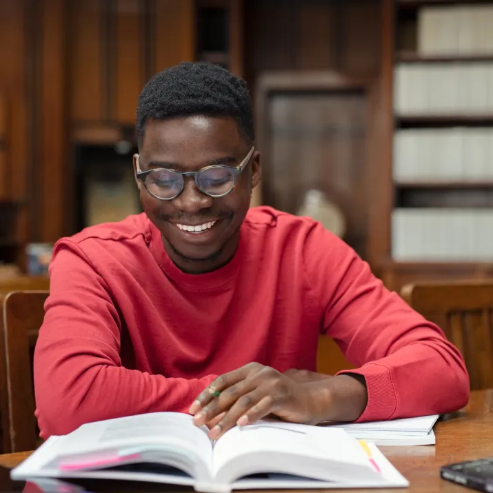 Student reading book library - left