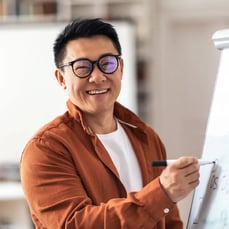 Teacher writing whiteboard lesson