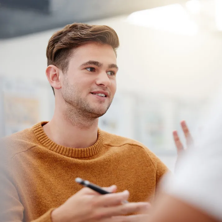 Male teacher gesturing while speaking in an indoor setting