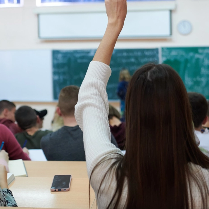Student raising hand in lecture hall