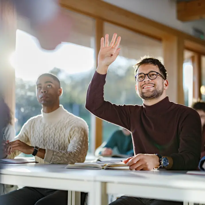 Student raising hand in modern classroom