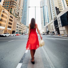 Woman in red dress walking in city street