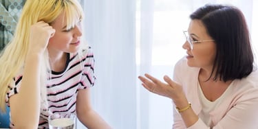 Female teacher talking to a student in a classroom setting