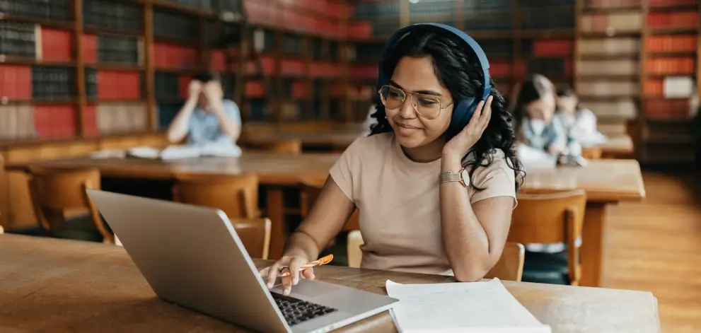 Student studying with headphones in library