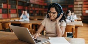 Student studying with headphones in library