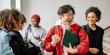 Group of students in a hallway engaged in conversation and celebration