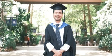 IDP IELTS test taker Adi graduating in park setting